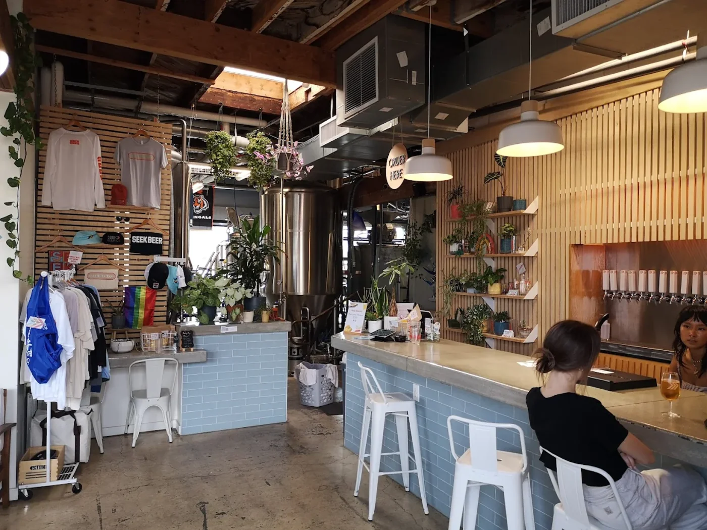 The plant-filled Seek Beer Co. bar with a tap wall and merch rack