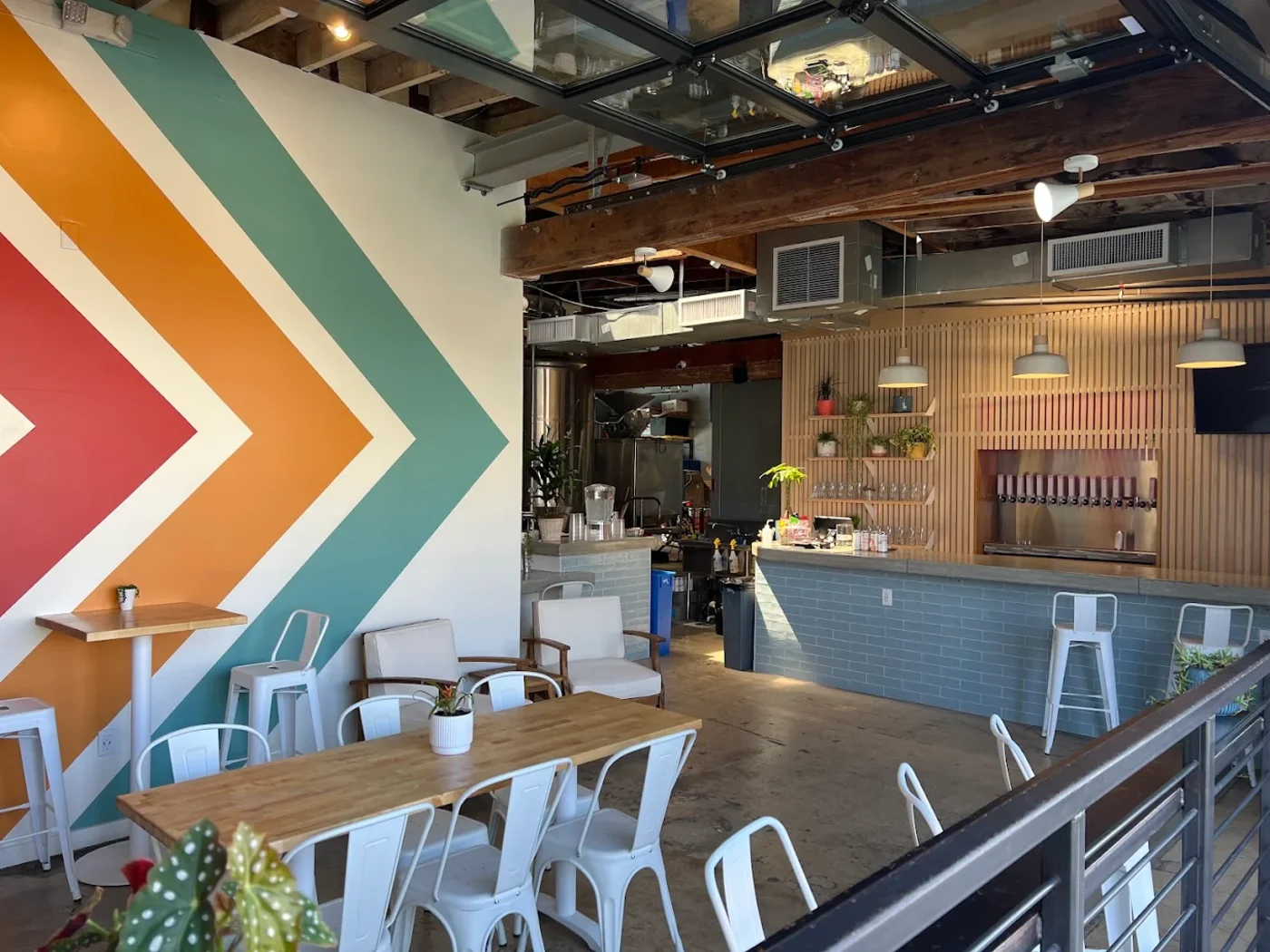 Seek Beer Co. taproom interior with a bold painted chevron mural wall and communal tables
